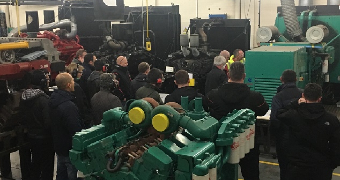 Technical training group learning around industrial equipment